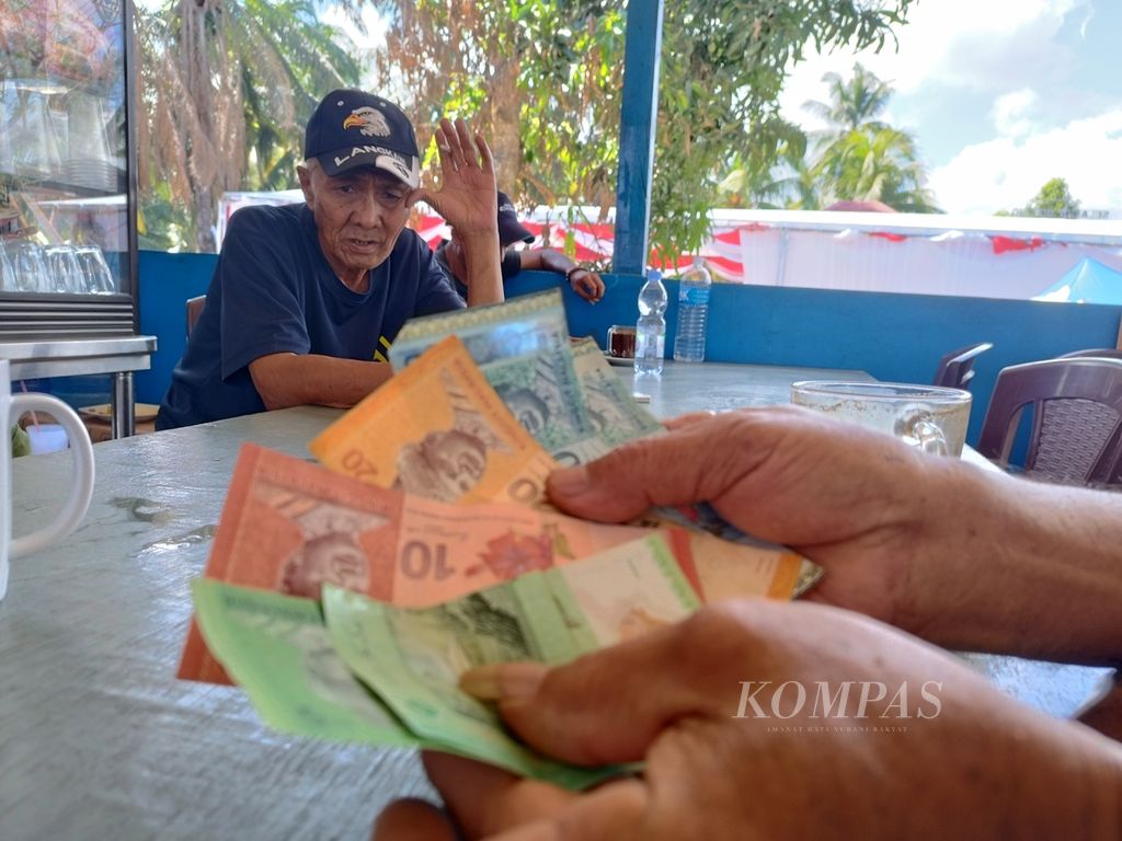 Warga menunjukkan mata uang ringgit miliknya di Desa Aji Kuning, Kabupaten Nunukan, Kalimantan Utara, Sabtu (24/2/2024).