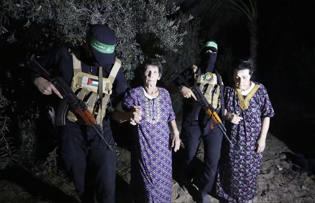 Photo captured from a video released by Brigade Al-Qassam through Telegram channel shows Yocheved Lifshitz (center) and Nurit Cooper (right) escorted by Hamas members when both were released and handed over to the International Committee of the Red Cross (ICRC) at an undisclosed location on Monday (23/10/2023).