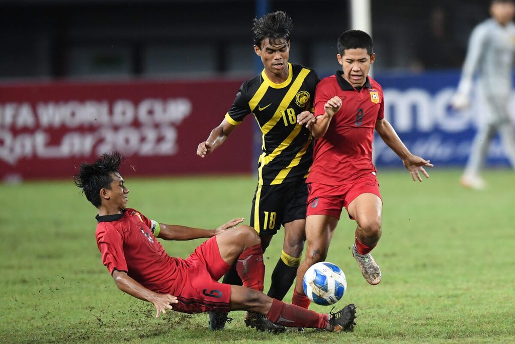 Pesepak bola Tim Nasional Malaysia U-19 Adam Farhan (tengah) berebut bola dengan sejumlah pesepak bolaTim Nasional Laos U-19 dalam babak final Piala AFF U-19 2022 di Stadion Patriot Candrabhaga, Bekasi, Jawa Barat, Jumat (15/7/2022). Malaysia juara setelah menang dengan skor 2-0.