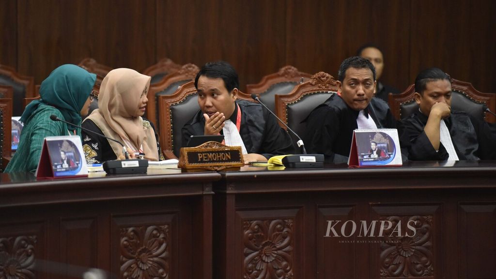 Anggota Dewan Pembina Perkumpulan untuk Pemilu dan Demokrasi, Titi Anggraini (kedua kiri), berbincang dengan Fadli Ramadhanil (tengah) saat mengikuti sidang putusan uji materi Undang-Undang Nomor 7 Tahun 2017 tentang Pemilu dan Undang-Undang Nomor 10 Tahun 2016 tentang Pemilihan Gubernur, Bupati, dan Wali Kota menjadi Undang-Undang Pilkada di Gedung Mahkamah Konstitusi, Jakarta, Rabu (26/2/2019). 
