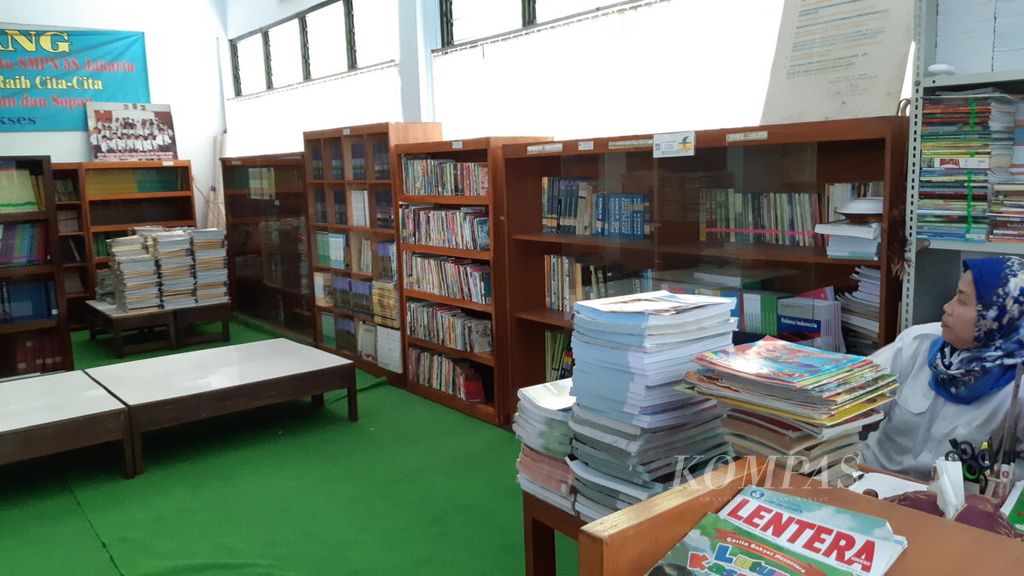 Suasana perpustakaan SMPN 58 Jakarta pada jam pelajaran. Siswa memilih meminjam buku untuk dibawa pulang.