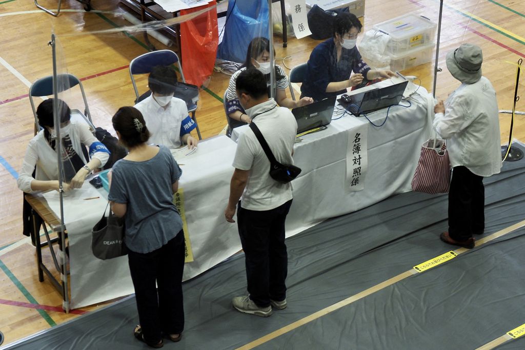 Para pemilih menerima surat suara saat pemungutan suara pemilihan anggota majelis tinggi parlemen Jepang di Tokyo, 10 Juli 2022. 
