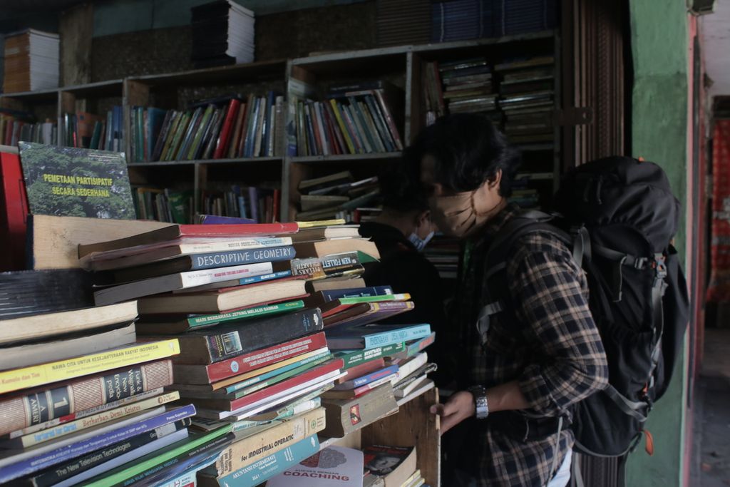 Seorang mengamati tumpukan buku di Toko Buku Perdana, Kecamatan Jatinangor, Kabupaten Sumedang, Jawa Barat, Kamis (8/4/2021). Seluruh buku di toko buku ini dijual seharga Rp 10.000 per buku untuk cuci gudang.