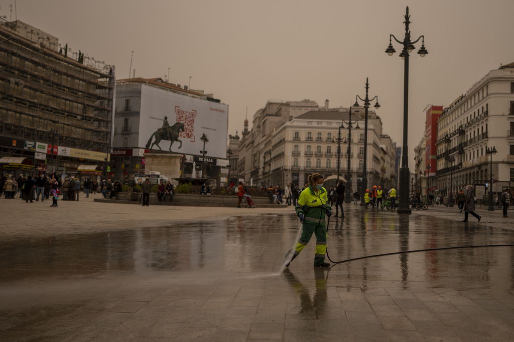 Petugas membersihkan debu dari Gurun Sahara di alun-alun Sol di Madrid, Spanyol, Selasa (15/3/2022). Spanyol mengeluarkan peringkat kualitas udara buruk ekstrem di sebagian besar wilayah negara itu setelah udara panas dari Sahara menebarkan debu setelah menyeberangi Laut Mediterania.