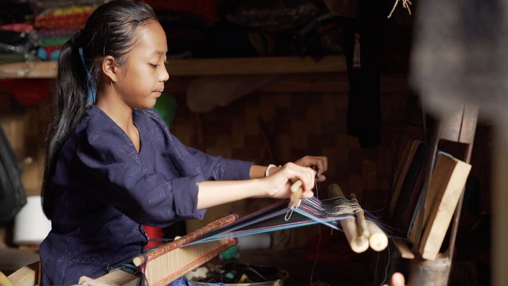 Ana (12) berkreasi menenun selendang suat songket di teras warung milik bibinya, Ambu Misna (49), di Kampung Balimbing, Desa Kanekes, Lebak, Banten, Jumat (28/10/2022).