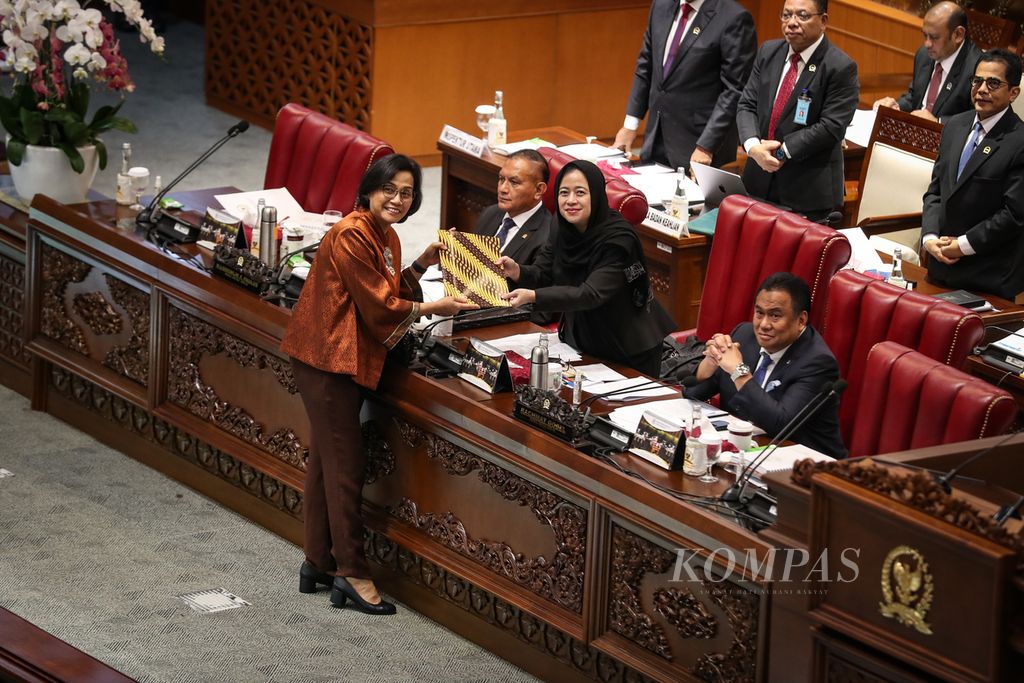 Menteri Keuangan Sri Mulyani (kiri) menyerahkan berkas terkait RUU tentang Pertanggungjawaban atas Pelaksanaan APBN Tahun Anggaran 2022 kepada Ketua DPR Puan Maharani (kanan) dalam rapat paripurna di Gedung Parlemen, Jakarta, Selasa (11/7/2023). 