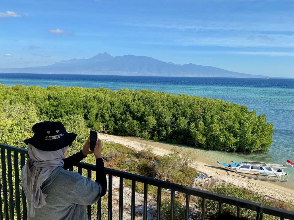 Wisatawan memotret keindahan lanskap Pulau Paserang dari menara pengawas Pulau Paserang di Kawasan Konservasi Taman Wisata Perairan Gili Balu, Kecamatan Poto Tano, Kabupaten Sumbawa Barat, NTB, Senin (17/7/2023). 