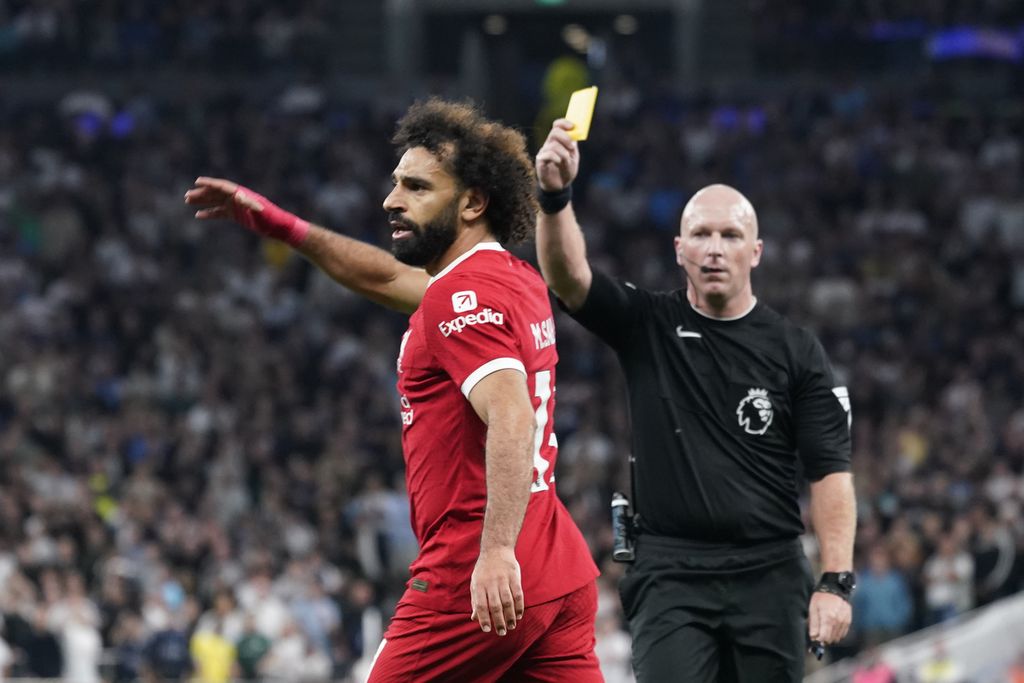 Wasit Simon Hooper memberikan kartu kuning kepada pemain Liverpool Mohamed Salah pada laga Liga Inggris antara Liverpool dan Tottenham Hotspur, Sabtu (30/9/2023).