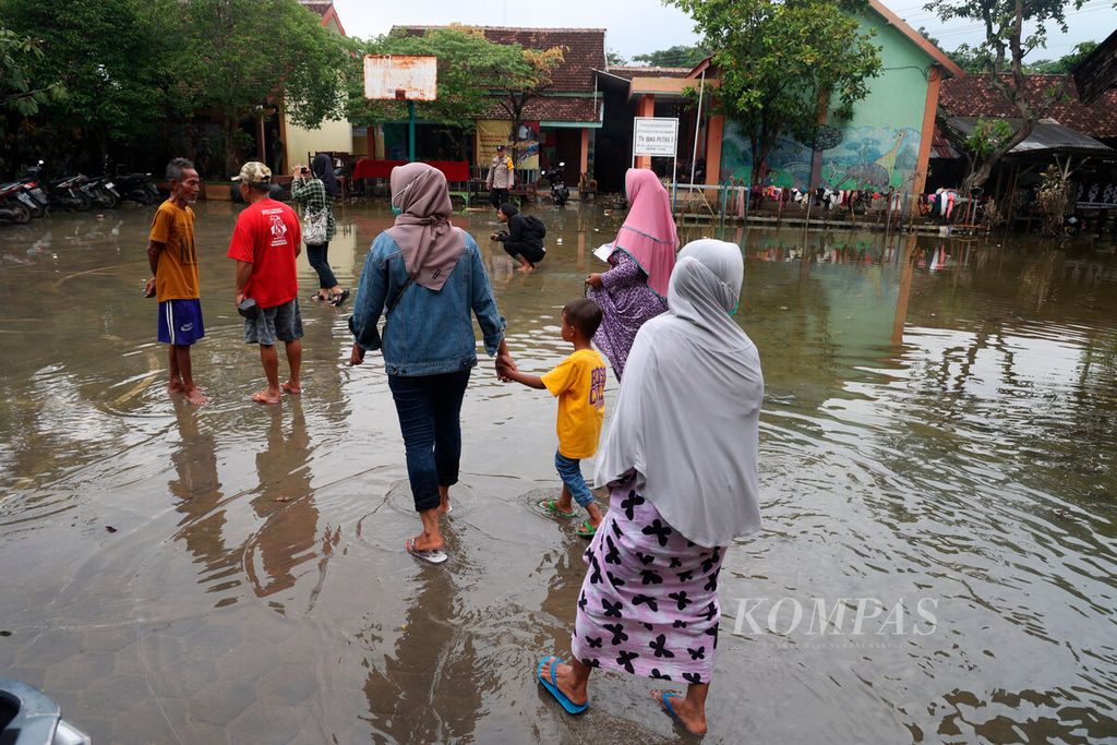 Genangan banjir yang masih tersisa di halaman di SD Negeri Wonorejo 1 saat didatangi warga untuk mengikuti pemungutan suara di Kecamatan Karanganyar, Kabupaten Demak, Jawa Tengah, Sabtu (24/2/2024). 