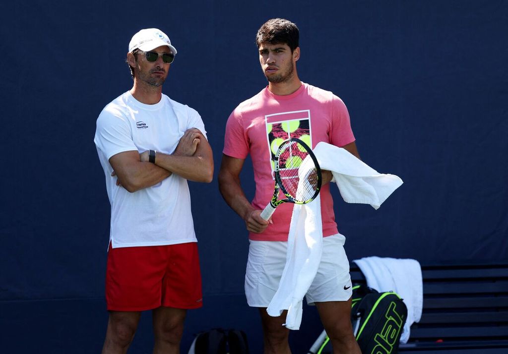 Carlos Alcaraz (kanan) berdiskusi dengan pelatihnya, Juan Carlos Ferrero, di tengah sesi latihan di Pusat Tenis Nasional Billie Jean King, New York, Minggu (27/8/2023), jelang berlaga pada Grand Slam AS Terbuka. 