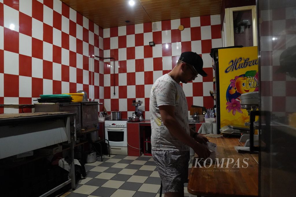 Miroslav Shylo (23) sedang mengambil bahan masakan di dapur restoran miliknya, di kota Trostyanets, Provinsi Sumy, Ukraina, Minggu (26/6/2022). Pada saat kota Trostyanets dikuasai Rusia, Miroslav membuat roti untuk dibagikan kepada warga. 