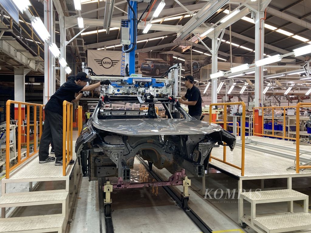 Para pekerja melakukan proses pemasangan atap kaca pada bodi BMW Seri 7 terbaru dengan alat khusus di fasilitas produksi PT Gaya Motor Production Line 2 di Jakarta Utara, Selasa (6/6/2023). BMW Group Indonesia menargetkan pertumbuhan penjualan dua digit pada tahun ini dibandingkan tahun lalu.