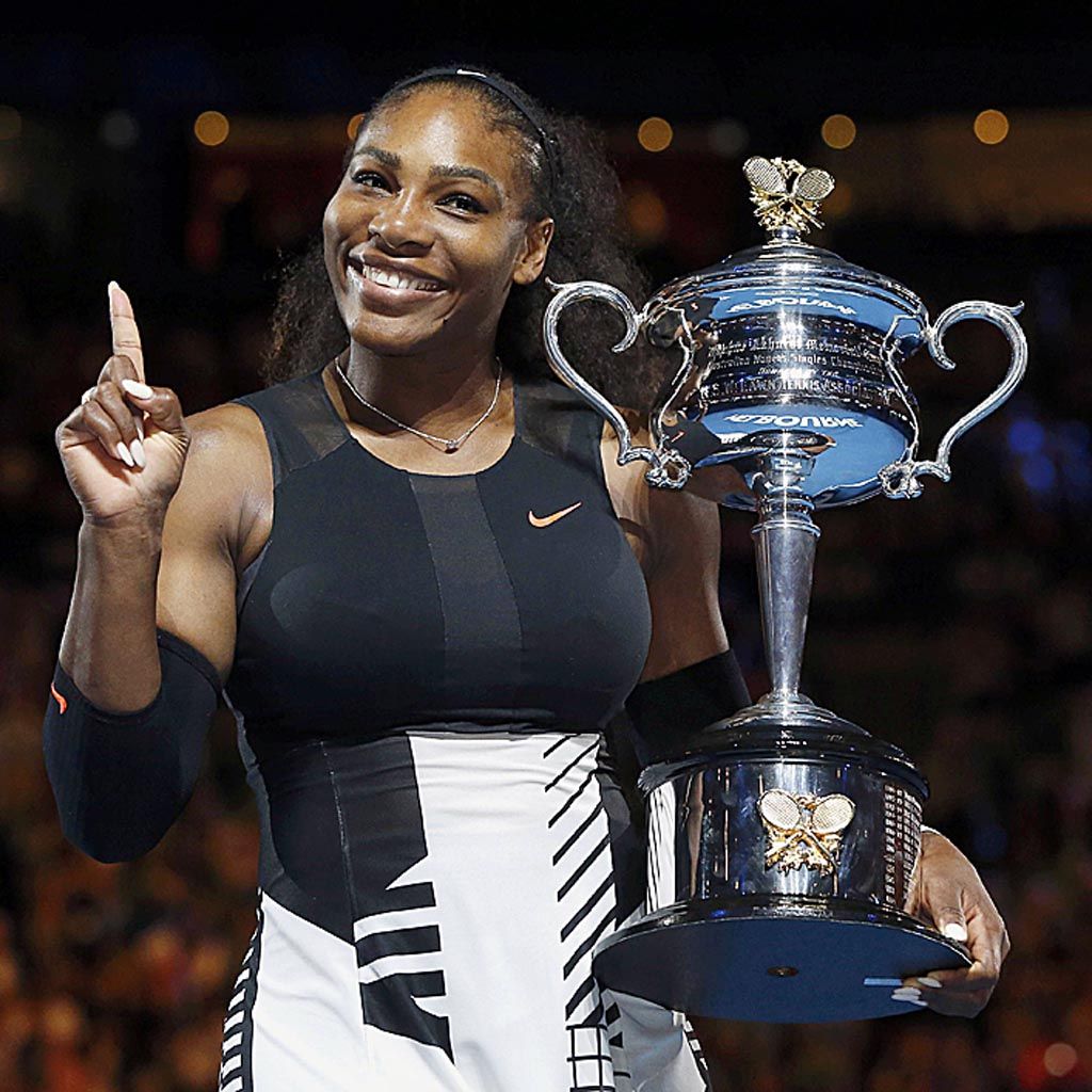  Serena Williams, petenis asal Amerika Serikat, tersenyum sambil memegang trofi setelah memenangi turnamen tenis Australia Terbuka melawan saudaranya, Venus Williams.  