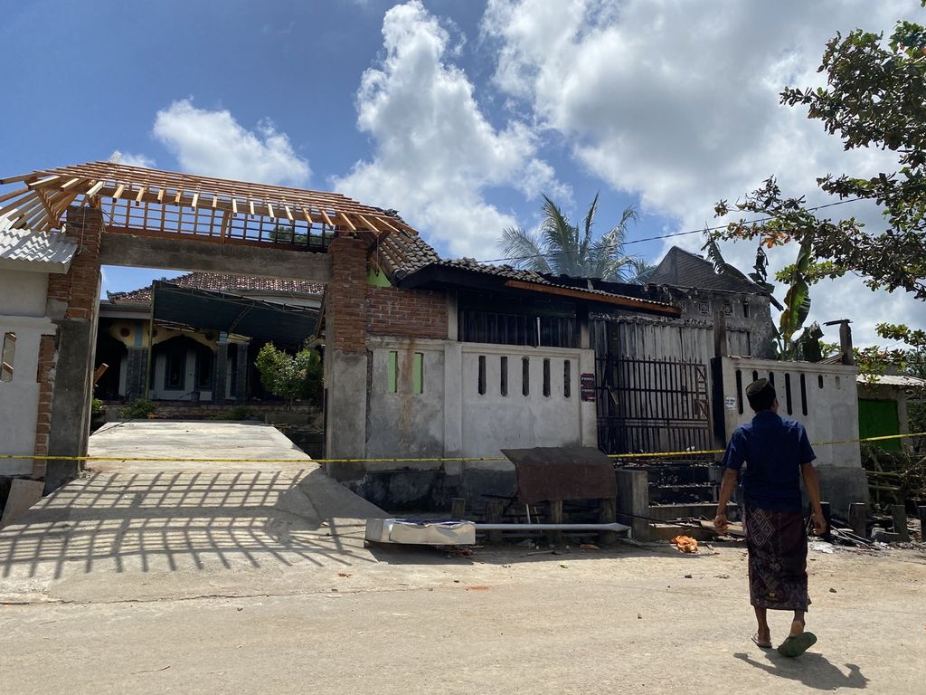 Seorang warga melintas di depan salah satu rumah yang terbakar di Dusun Ganjar, Desa Mareje, Kecamatan Lembar, Kabupaten Lombok Barat, Nusa Tenggara Barat, Rabu (4/5/2022). 