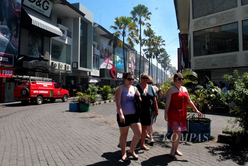 A number of foreign tourists pass through the shopping center area of Kuta Square, Kuta, Badung, Bali.