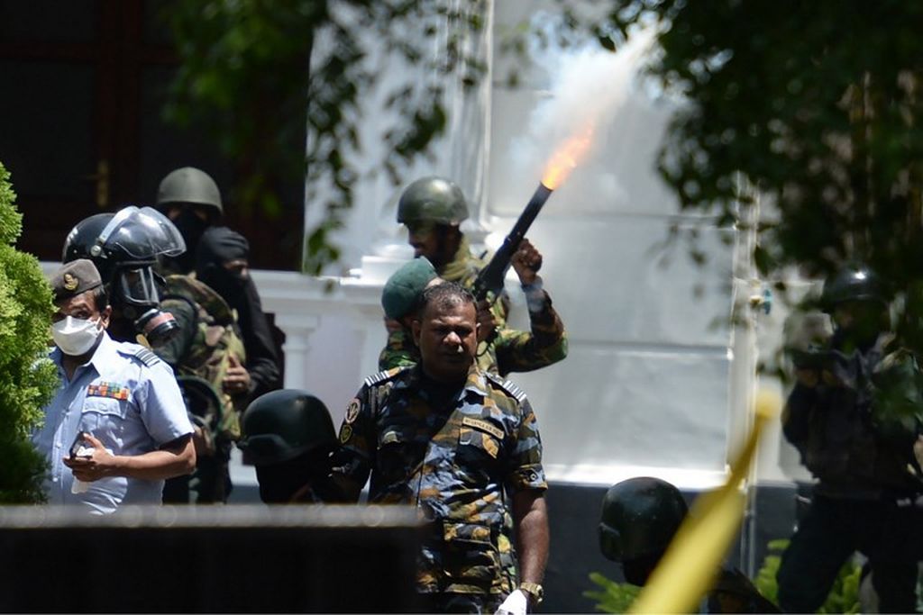 Seorang personel militer menembakkan tabung gas air mata untuk membubarkan demonstran selama protes anti-pemerintah di luar kantor Perdana Menteri Sri Lanka di Colombo, Sri Lanka, Rabu, 13 Juli 2022. 