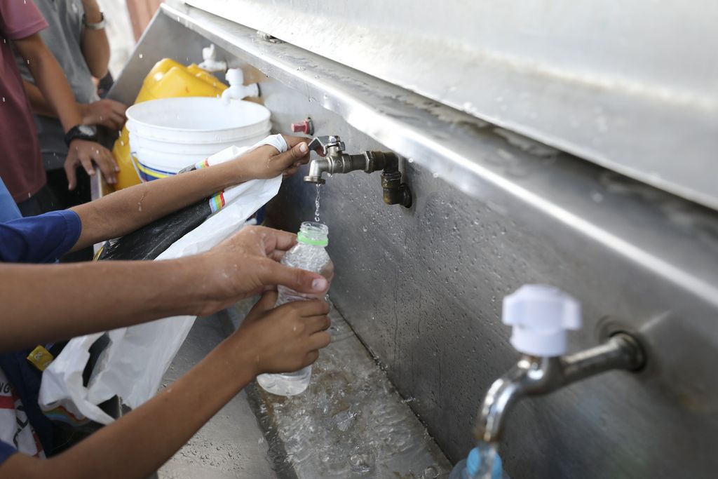Warga Gaza mengisi botol ataupun tempat lainnya untuk mendapatkan persediaan air minum yang bisa diambil di Kamp Pengungsi Nuseirat di Jalur Gaza, Selasa (17/10/2023). 