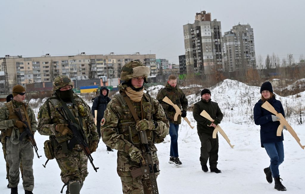 Sejumlah warga sipil memegang replika kayu senapan Kalashnikov ketika mengikuti latihan tempur warga sipil di Kiev, Ukraina (6/2/2022). Ratusan ribu warga Ukraina telah menjalani pelatihan tempur sejak beberapa bulan lalu, mempersiapkan diri membantu militer Ukraina menghadapi kemungkinan invasi Rusia ke negara tersebut. 