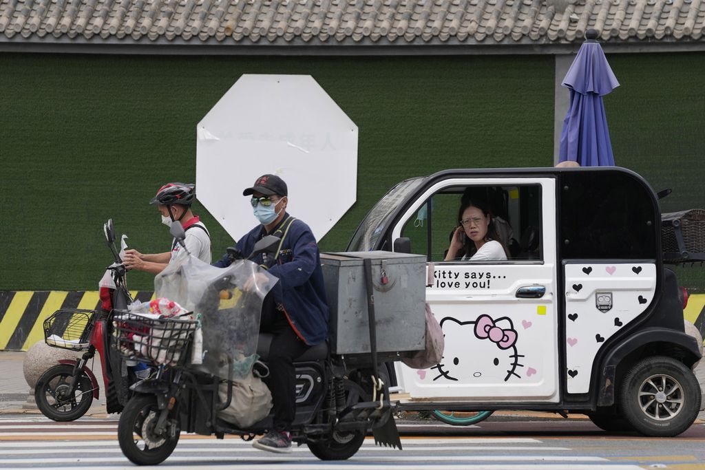 Penduduk Beijing berkendara di sebuah jalan di Beijing, Senin (11/7/2022).