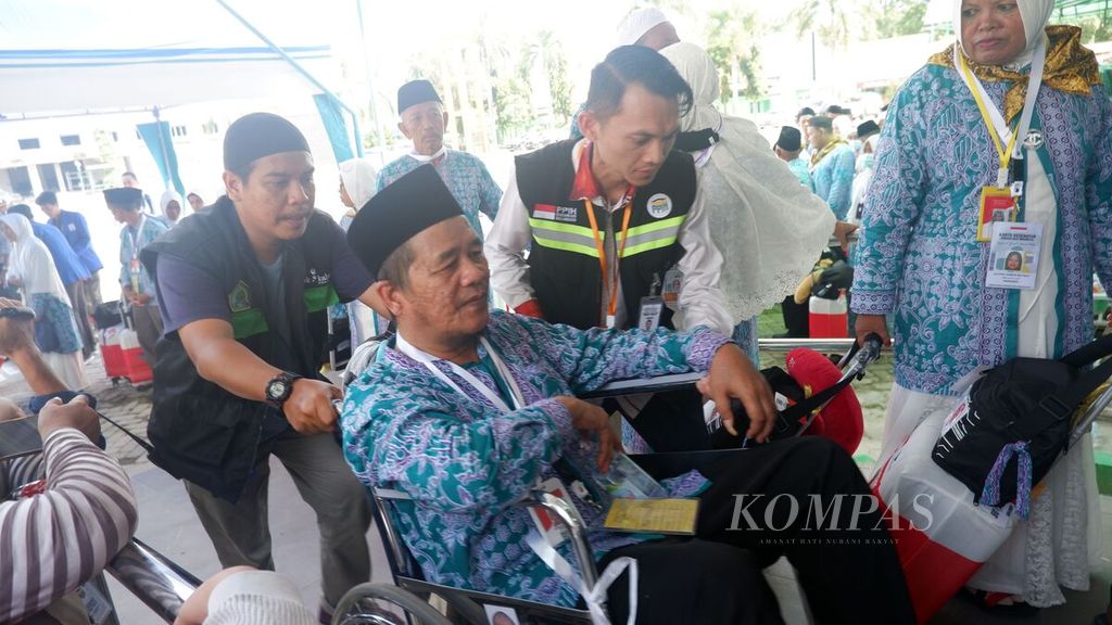 Petugas haji membantu jemaah berkursi roda melewati pemeriksaan keamanan penumpang dan barang bawaan di Asrama Haji Embarkasi Banjarmasin di Banjarbaru, Kalimantan Selatan, Senin (29/5/2023). 