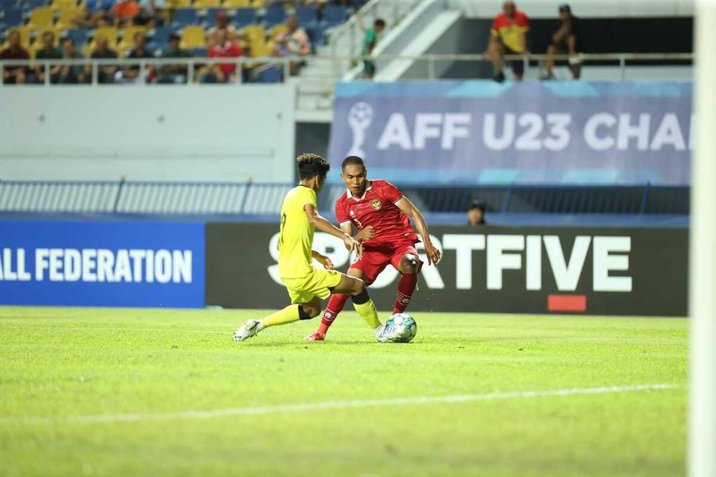 Pemain tim sepak bola Indonesia U-23, Frengky Missa, berusaha mengecoh pemain belakang Malaysia dalam laga Piala AFF U-23 di Stadion Provinsi Rayong, Thailand, Jumat (18/8/2023) malam. Indonesia tergabung di Grup B bersama Malaysia dan Timor Leste