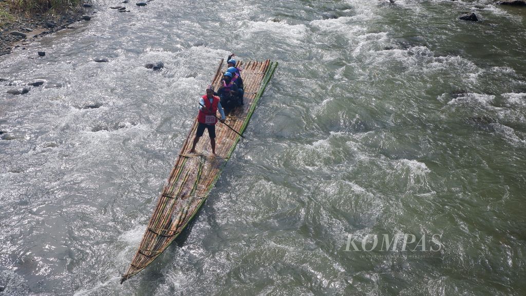 Sebuah rakit bambu membawa wisatawan menyusuri jeram Sungai Amandit di Kecamatan Loksado, Kabupaten Hulu Sungai Selatan, Kalimantan Selatan, Minggu (9/7/2023).