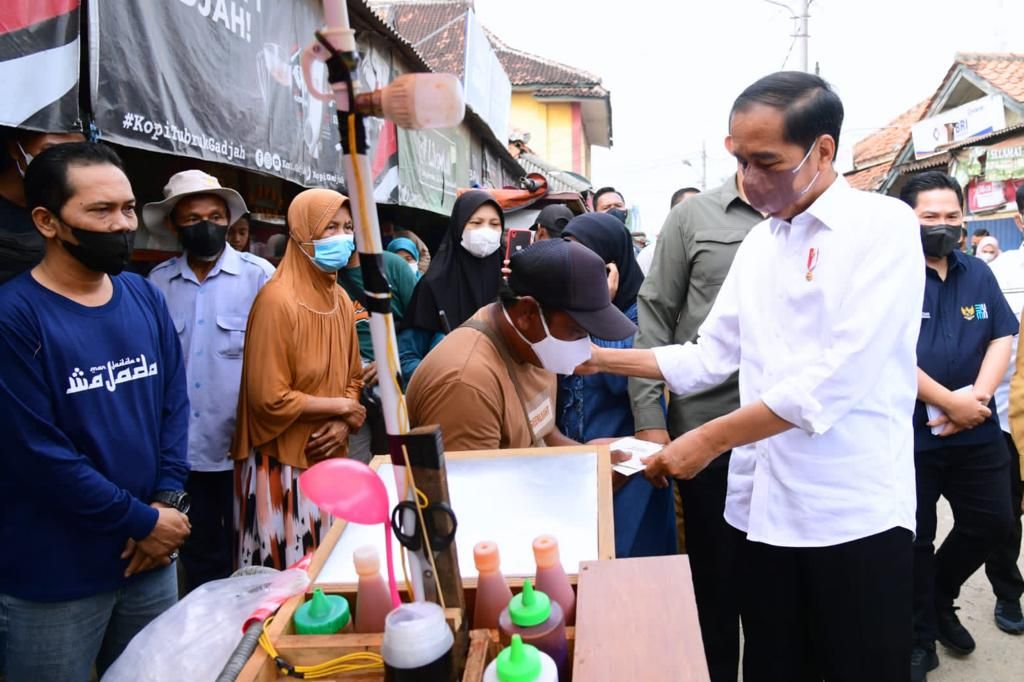Presiden Joko Widodo menyerahkan bantuan sosial di Pasar Sukamandi, Kabupaten Subang, Jawa Barat, Selasa (12/7/2022).