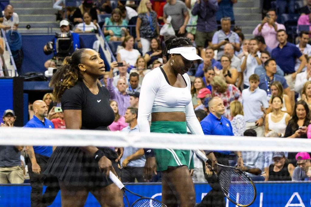 Ganda putri AS Serena Williams (kiri) dan Venus Williams meninggalkan lapangan setelah kalah dari Lucie Hradecka/Linda Noskova (Ceko) pada babak pertama AS Terbuka, di Pusat Tenis Nasional Billie Jean King, Flushing Meadows, New York, Kamis (1/9/2022). Serena/Venus kalah dengan skor 6-7 (5), 4-6.