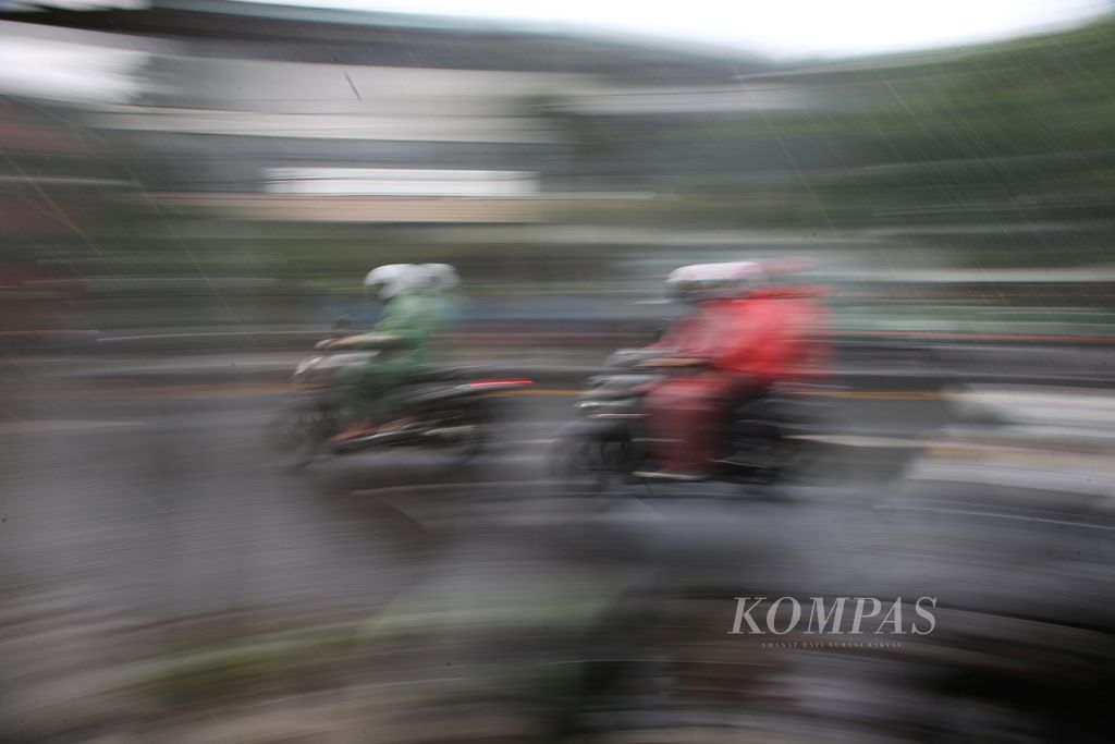 Warga menggunakan jas hujan saat menembus hujan deras yang mengguyur kawasan Ciputat, Tangerang Selatan, Banten, Rabu (8/6/2022). Meskipun sudah memasuki musim kemarau, hujan deras masih sering turun di Ibu Kota dan sekitarnya. 