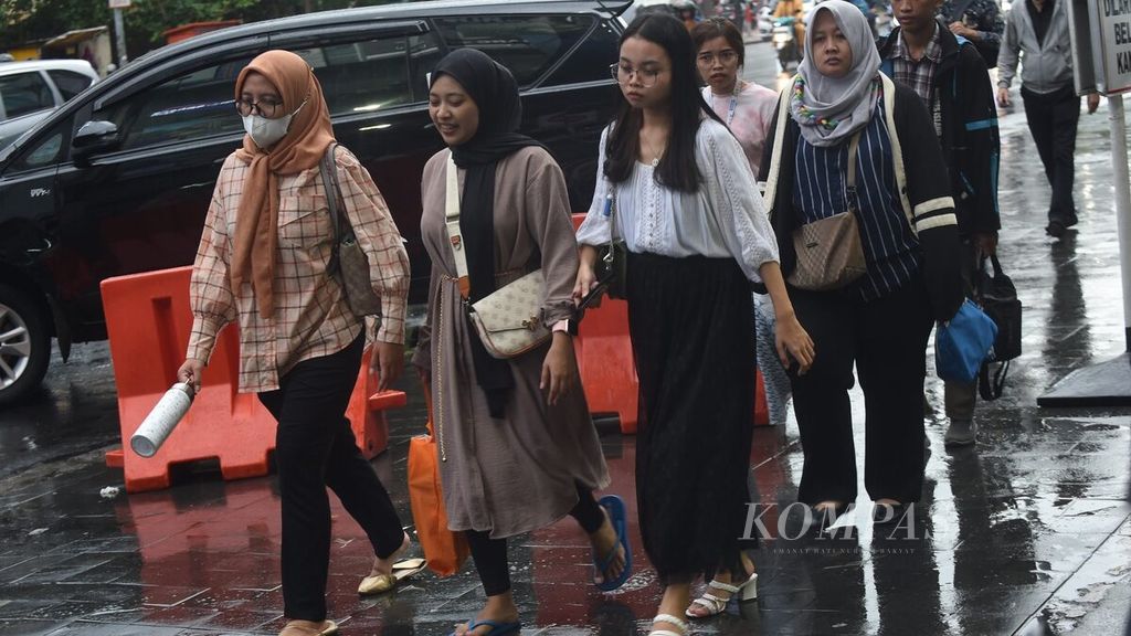 Pekerja pulang dari kantor di Jalan Embong Malang, Surabaya, Senin (26/2/2024). Saat ini, sebagian besar kelas menengah usia 17-40 tahun kerepotan mengatur pengeluaran.