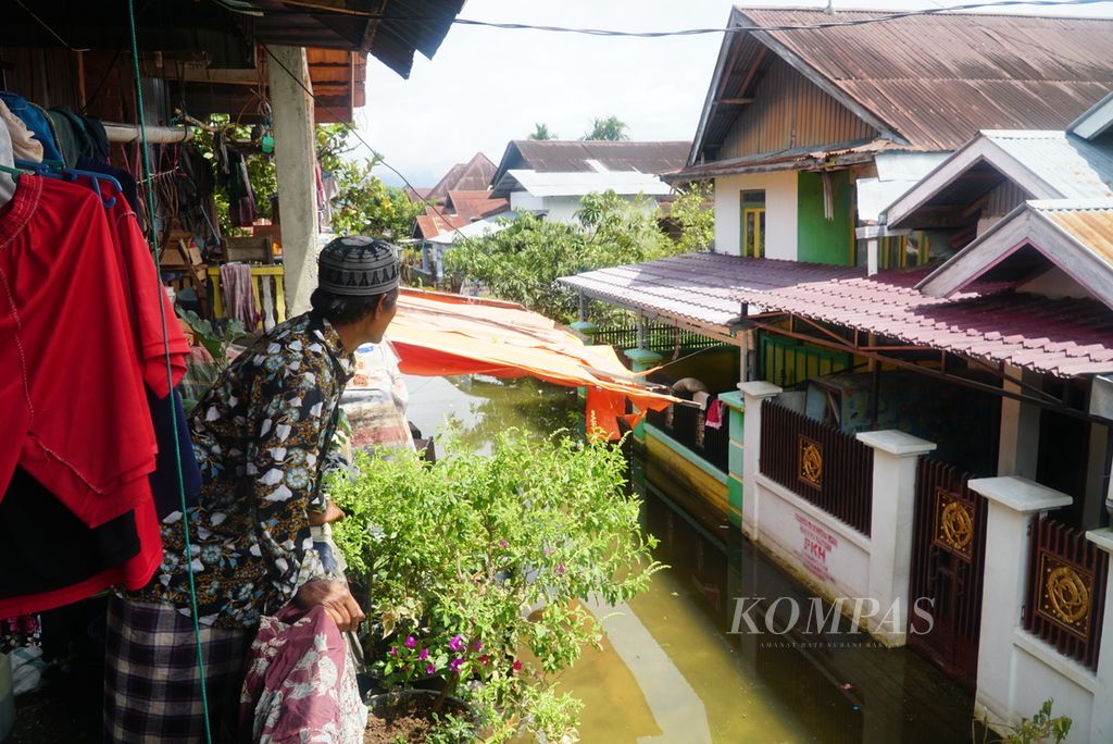Wahidin (62) mengamati kondisi banjir di rumah sekitarnya di Desa Koto Dian, Kecamatan Keliling Danau, Kabupaten Kerinci, Jambi, Kamis (18/1/2024).