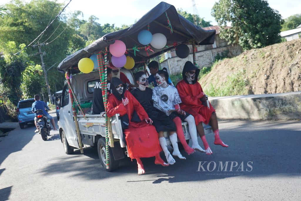 Kelompok sinterklas dan piet hitam dari komunitas pemuda Second Family mengendarai mobil pikap untuk berkunjung ke rumah-rumah warga di Manado, Sulawesi Utara, Minggu (11/12/2022), dan memberikan hadiah Natal kepada anak-anak.