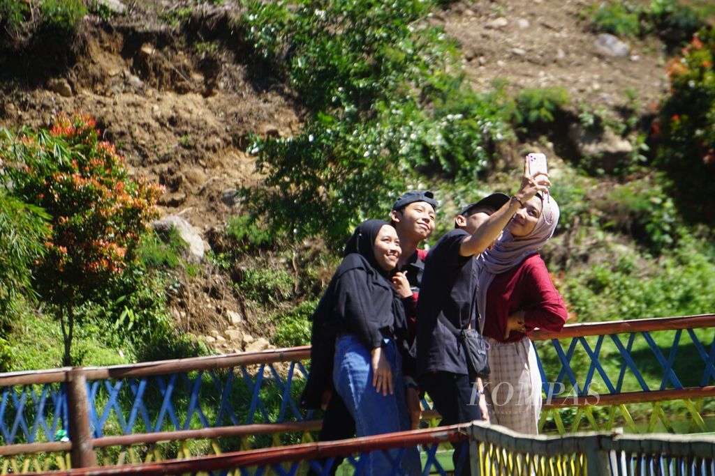 Pengunjung berfoto di Telaga Kumpe di Desa Gununglurah, Kecamatan Cilongok, Kabupaten Banyumas, Jawa Tengah, Rabu (12/7/2023).
