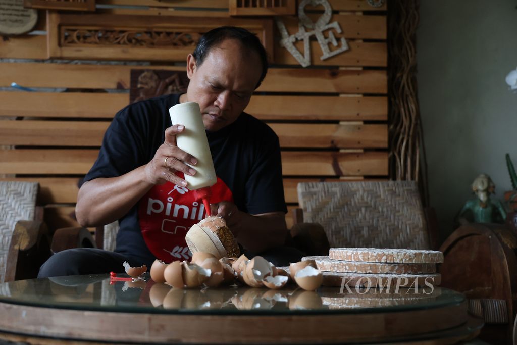 Heriyanto (52) works on wooden tableware at his Pinilih Craft business in North Kramat Village, North Magelang District, Magelang City, Central Java, on Monday (17/10/2022).