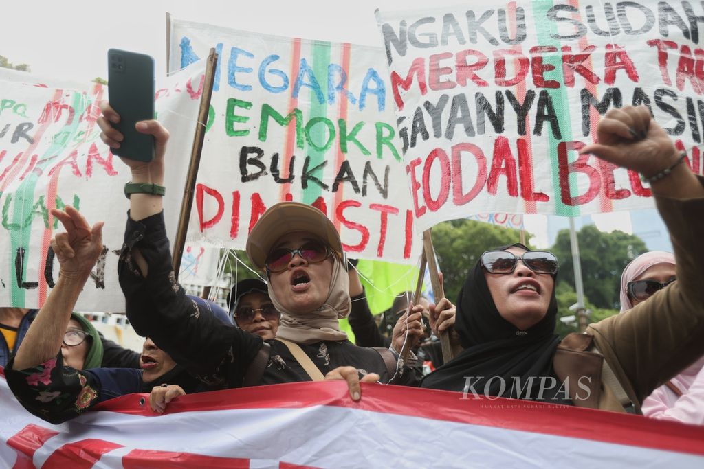 Peserta aksi yang tergabung dalam Poros Buruh berteriak menyuarakan tuntutan di depan Kantor Komisi Pemilihan Umum, Jakarta, Rabu (21/2/2024).   