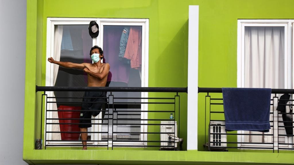 Dari balkon kamar tempat perawatan, pasien orang tanpa gejala Covid-19 mengikuti senam pagi bersama tenaga medis dan sukarelawan di rumah singgah karantina Covid-19 di Kabupaten Tangerang, Banten, Selasa (26/5/2020).