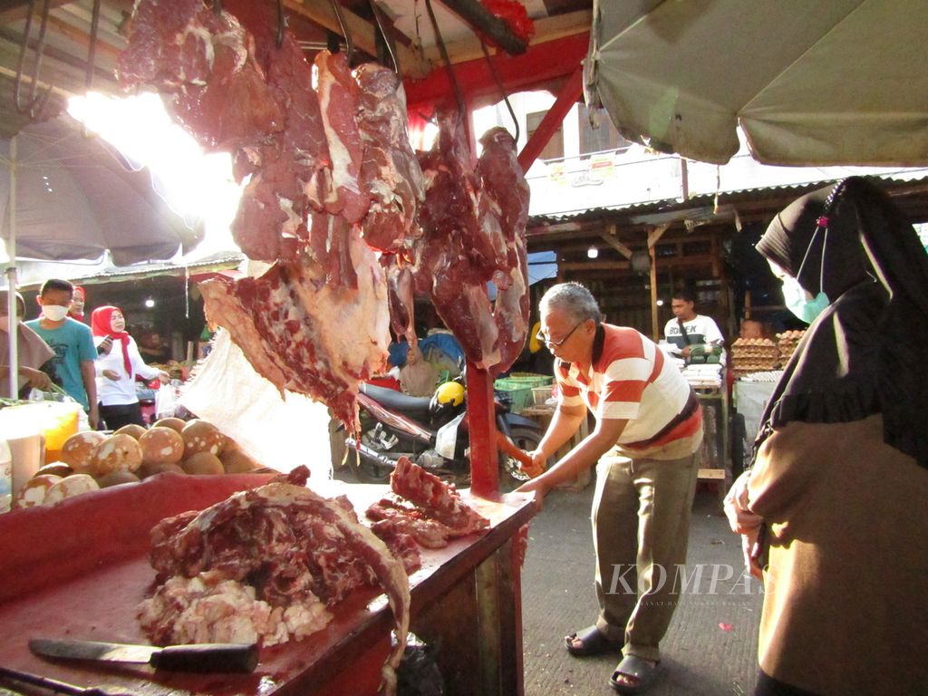 Pedagang daging sapi di Pasar Pasir Gintung, Kota Bandar Lampung, sedang melayani pembeli di lapaknya, Selasa (5/7/2022). Hingga kini, wabah PMK tidak membuat harga daging sapi di Kota Bandar Lampung bergejolak. 