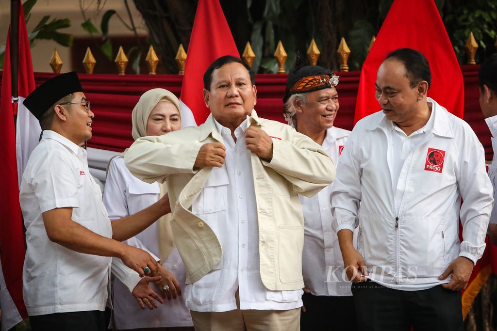 Bakal calon presiden dari Partai Gerindra, Prabowo Subianto (tengah), mengenakan kemeja Projo disaksikan Ketua Umum Projo Budi Arie Setiadi (kanan) dan Sekretaris Jenderal Projo Handoko (kiri) di Jalan Kertanegara, Jakarta, Sabtu (14/10/2023). 