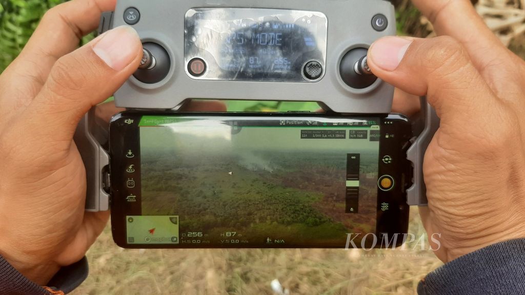 Salah satu tim patroli Badan Penanggulangan Bencana Daerah Provinsi Kalimantan Barat sedang memantau salah satu lokasi lahan gambut di Kabupaten Kubu Raya yang rawan kebakaran menggunakan <i>drone</i>, Jumat (22/9/2023). Dari layar tampak ada kepulan asap dari salah satu lahan gambut.