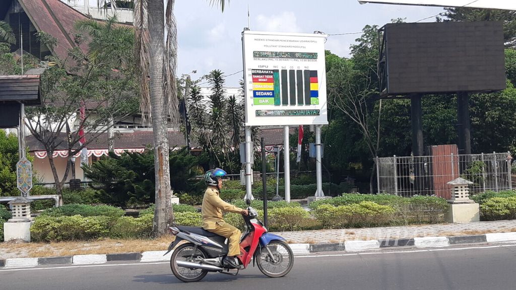 Pengendara motor melintas di depan alat pendeteksi kualitas udara atau Indeks Standar Pencemaran Udara (ISPU) di kawasan Bundaran Besar, Kota Palangkaraya, Kalimantan Tengah, Selasa (6/8/2019).
