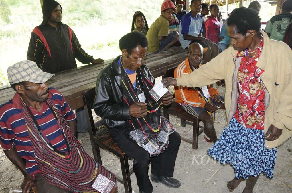 Seusai menggunakan hak suaranya di TPS Eroma 1, Distrik Kurima, Kabupaten Yahukimo, Papua, pemilih memasukkan surat suara Pemilihan Presiden ke dalam noken (tas kantong tradisional), Rabu (8/7/2009).