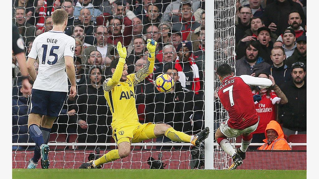 Striker Arsenal, Alexis Sanchez (kanan), mencetak gol ke gawang Tottenham Hotspur yang dijaga kiper Hugo Lloris (tengah) pada laga Liga Inggris di Stadion Emirates, London, Sabtu (18/11). Arsenal menang 2-0.