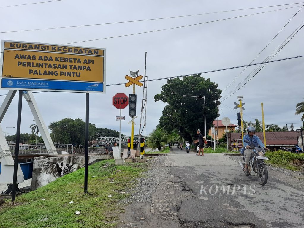 Pengendara melewati pelintasan sebidang jalur kereta api di Kelurahan Jati, Kecamatan Padang Timur, Kota Padang, Sumatera Barat, Senin (12/12/2022). 
