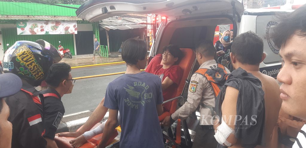 Seorang pemuda dievakuasi karena mengalami luka bakar akibat kebakaran di pinggir Jalan Raya Bogor Km 21 di Kelurahan Kampung Rambutan, Kecamatan Ciracas, Jakarta Timur, Minggu (25/12/2022) siang.