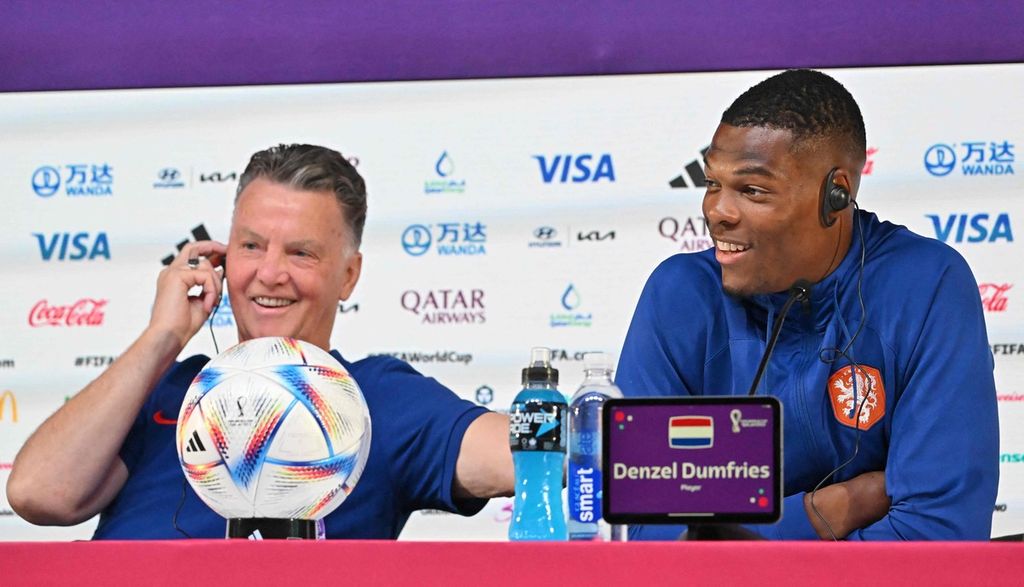 Pelatih Belanda Louis Van Gaal (kiri) dan bek Belanda, Denzel Dumfries, tersenyum mendengar pertanyaan wartawan pada konferensi pers di Qatar National Convention Center, Doha, Kamis (24/22/2022). Van Gaal (71) akan memimpin Belanda pada laga kedua melawan Ekuador, Jumat (25/11).