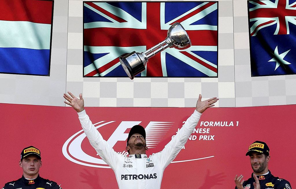 Pebalap Inggris di tim Mercedes, Lewis Hamilton (tengah), merayakan kemenangannya di balapan F1 seri Jepang di Sirkuit Suzuka, Minggu (8/10). Posisi kedua ditempati pebalap Belanda di tim Red Bull, Max Verstappen (kiri), dan posisi ketiga ditempati pebalap Australia di tim Red Bull, Daniel Ricciardo.