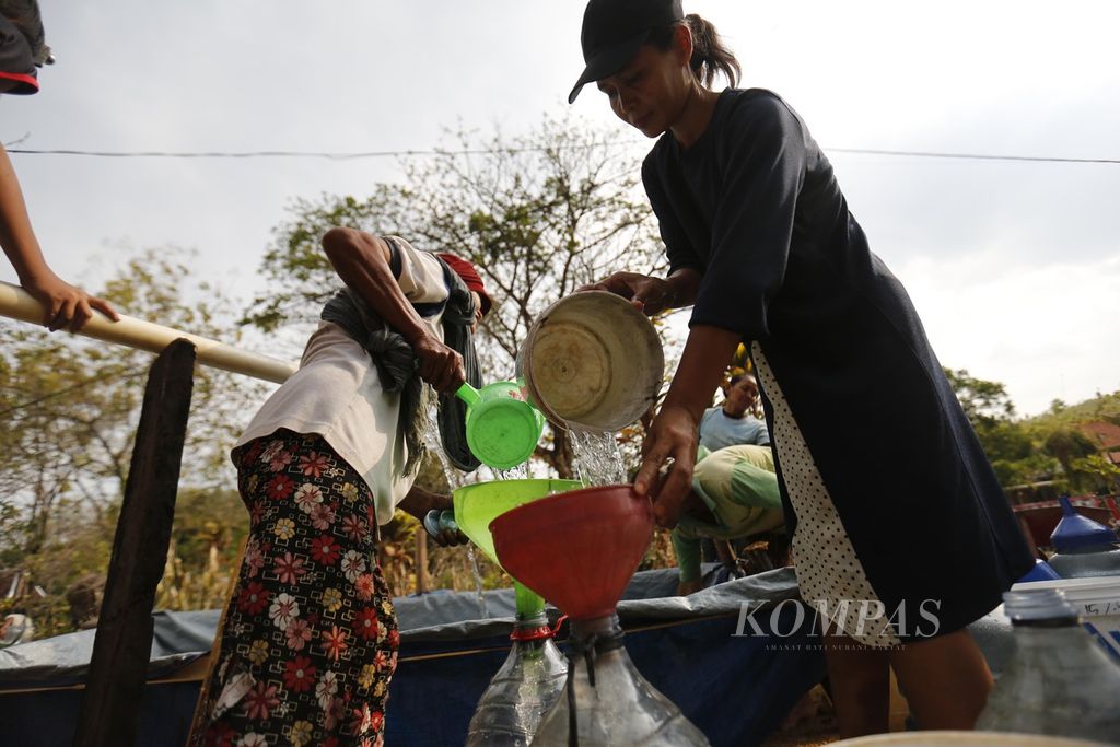 Warga Dusun Kalitlawah, Ngaren, Juwangi, Boyolali, Jawa Tengah, antre mendapatkan air bersih yang dibagikan secara gratis oleh pemuda karang taruna setempat, Kamis (14/9/2023). Musim kemarau berkepanjangan menyebabkan warga sudah lebih dari dua bulan terakhir ini kesulitan mendapatkan air bersih.