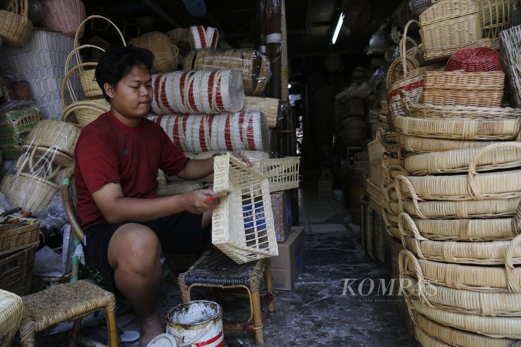 Gunawan mempelitur peralatan rumah tangga berbahan rotan pesanan pelanggan di bengkel kerjanya di kawasan Grogol, Jakarta Barat, Selasa (26/9/2023). Gunawan mengaku sejak 2020 ia membuka lapak di lokapasar, ada saja barang dagangannya yang terjual setiap harinya. 