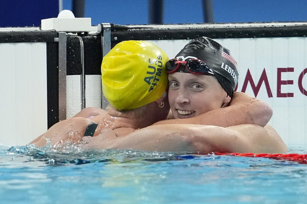 Perenang Australia, Ariarne Titmus (kiri), berpelukan denan perenang Amerika Serikat, Katie Ledecky, usai memenangi emas nomor 400 meter gaya bebas putri Olimpiade Paris 2024, Minggu (28/7/2024).