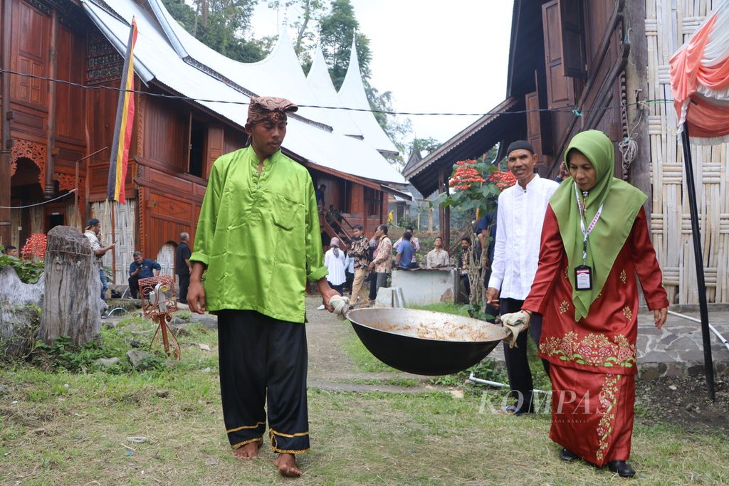 Warga membawa rendang yang sudah selesai dimasak untuk wisatawan di Nagari Sumpur, Kecamatan Batipuh Selatan, Kabupaten Tanah Datar, Sumatera Barat, Kamis (22/6/2023). 